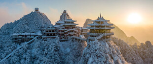 雪覆古建筑日出映美景