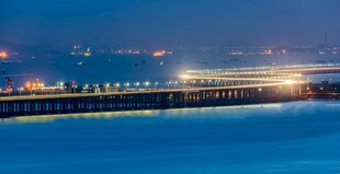 海滨夜景璀璨灯火映海面