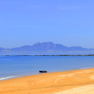 金色沙滩与远处山海风光