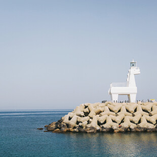 海边石堆上的白色灯塔