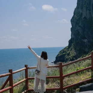 女子海边凭栏舒展身姿