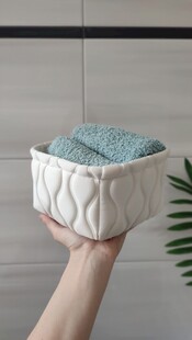 手托花纹容器装蓝色毛巾