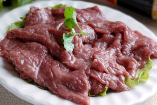 新鲜生牛肉片点缀绿叶