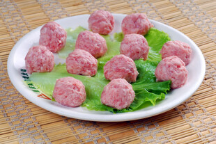 新鲜肉丸摆于翠绿生菜上