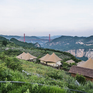 山间草屋与远处桥梁美景