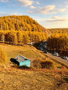秋日山坡上的小屋与公路