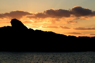 夕阳下的山与海面剪影