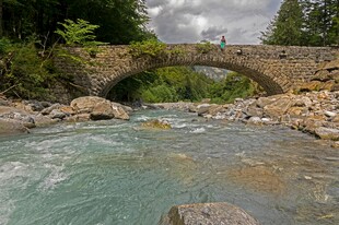 山间石拱横跨湍急溪流