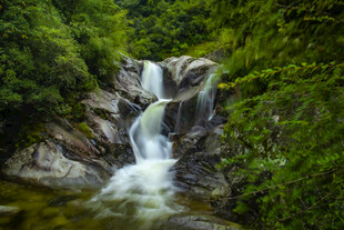 山间瀑布绿意环绕之景