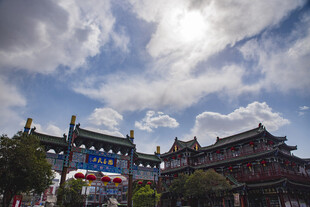 古建牌坊映于蓝天白云下