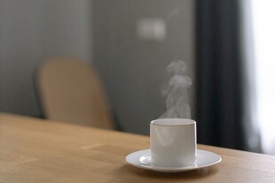 桌上热气腾腾的白色咖啡杯