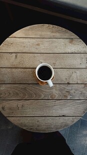 木质圆桌上的白色咖啡杯