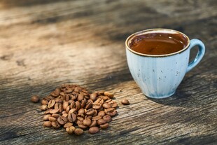 木桌上的咖啡杯与咖啡豆
