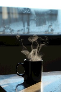 窗边热气腾腾的黑色咖啡杯