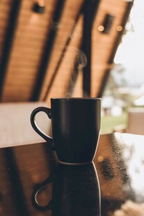 黑色咖啡杯置于反光桌面