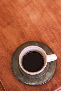 木质桌面上的黑咖啡杯