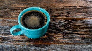 蓝色咖啡杯置于木质桌面