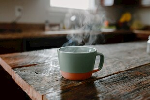 木桌上热气腾腾的马克杯
