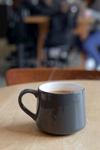 木桌上的灰色咖啡杯
