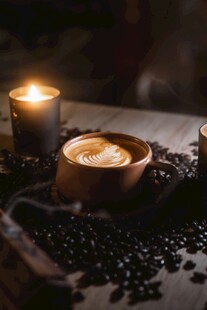 烛光下的咖啡豆与咖啡杯