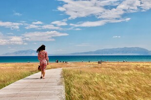 海边木板路上漫步的女子