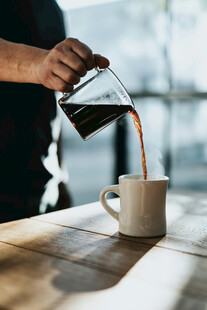 手冲咖啡倒入白色咖啡杯