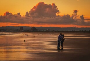 夕阳下情侣漫步海滩