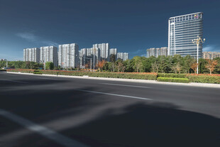 城市宽阔道路旁的现代建筑群