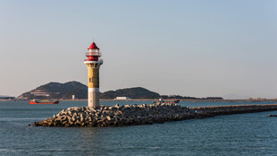 海边灯塔屹立于防波堤