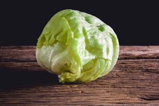 一颗新鲜圆生菜置于木桌