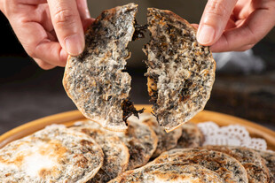 双手捧起梅干菜饼