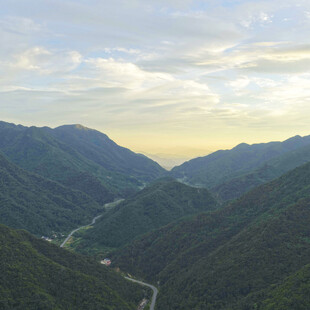 山间公路穿梭于葱郁群山