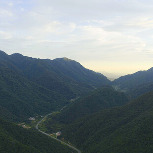山间公路蜿蜒于翠绿群山