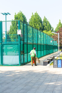 球场围网旁的环卫工人