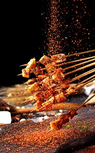 正在撒料的烤羊肉串