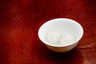红木板上的白瓷碗