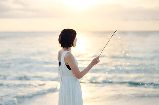 海边夕阳下自拍的女子