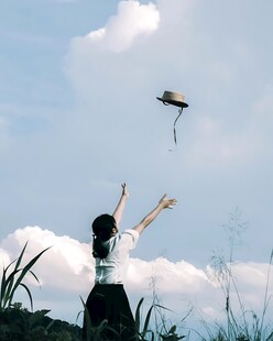 晴空下抛帽的少女